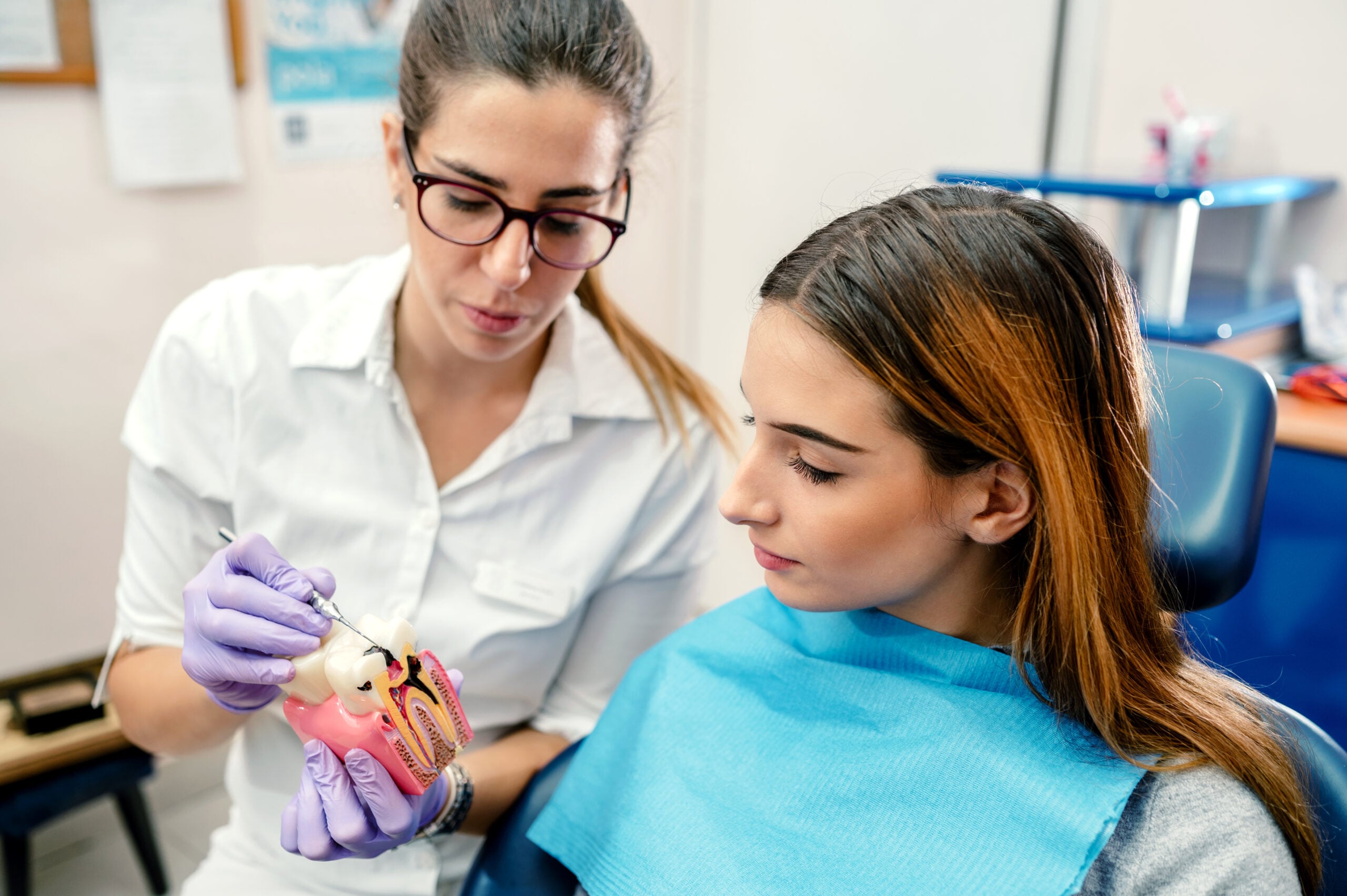 Patient looking at her smile in a handheld mirror at the dentist